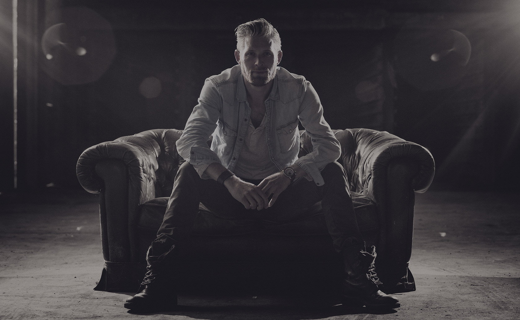 Man seated on armchair in dark room