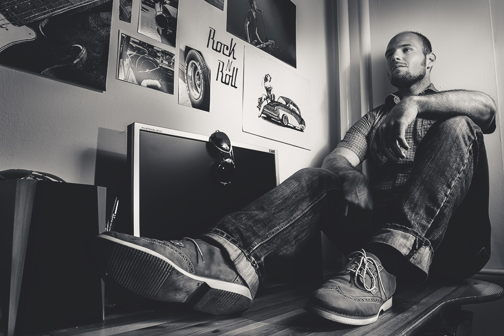 Man sitting on floor beside rock posters.