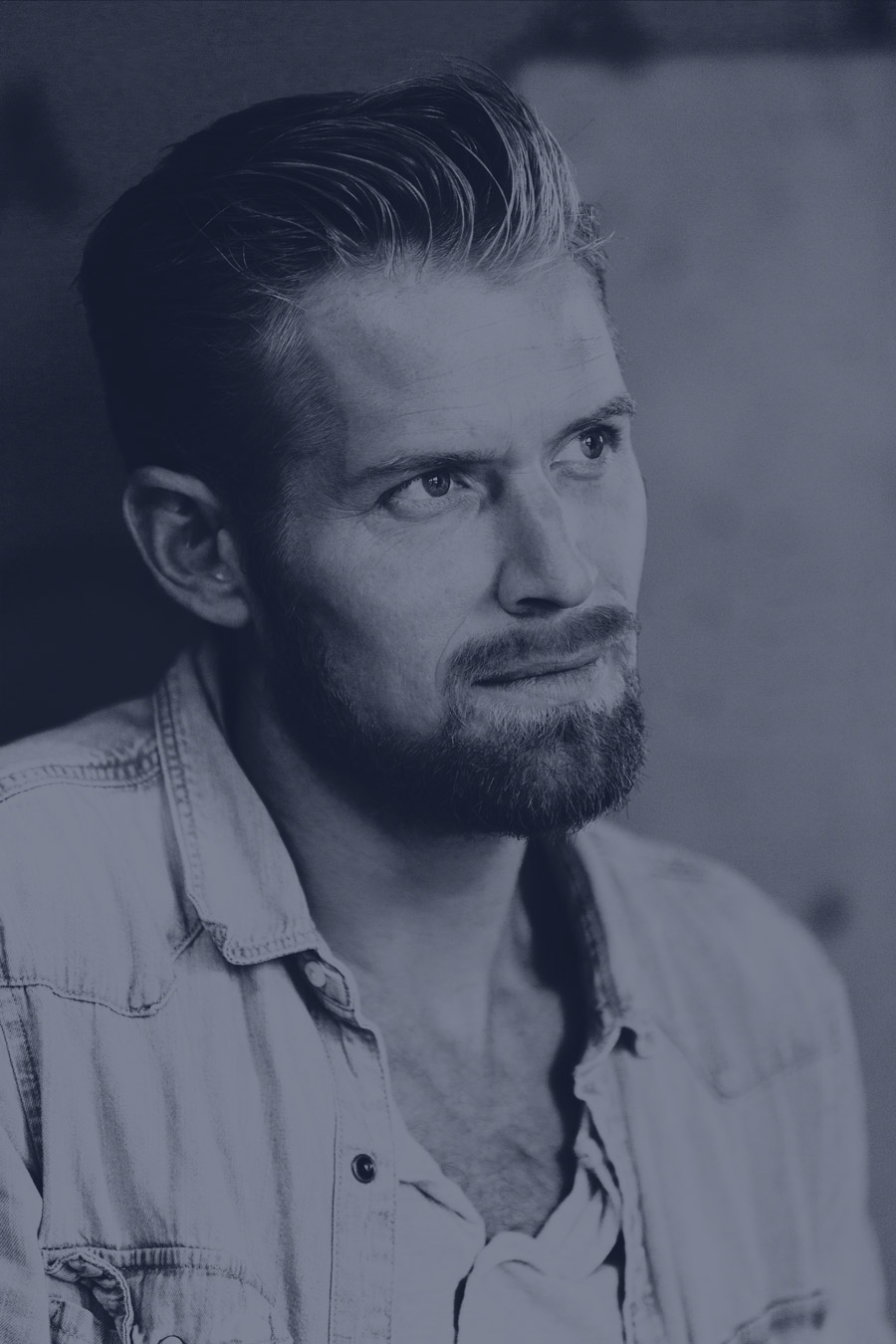 Thoughtful bearded man in denim shirt