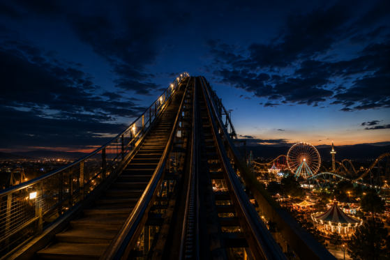 Night roller coaster climb with illuminated Ferris wheel